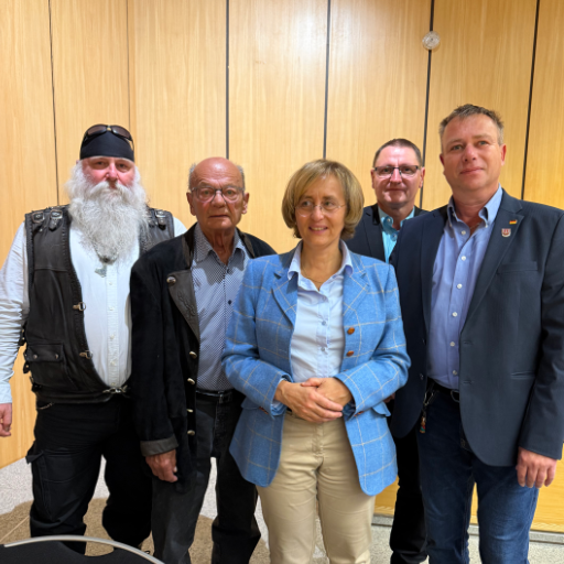 Gruppenfoto von Teilnehmern der Veranstaltung in Bielefeld vor einer Holzwand